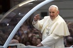 Pope Francis waves from his popemobile as he makes his way into central Rio de Janeiro, Brazil, Monday, July 22, 2013.