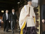 In this Thursday, Dec. 26, 2013 file photo, Japanese Prime Minister Shinzo Abe, second from left, follows a Shinto priest to pay respect for the war dead at Yasukuni Shrine in Tokyo.