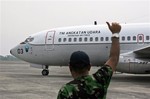 A ground crew gives an 'OK' sign to the pilots of an Indonesian Air Force Boeing 737 "Surveiller" of the 5th Air Squadron "Black Mermaids" as they prepare to take off for a search operation for the missing Malaysia Airlines jetliner MH370, at Suwondo Air base in Medan, North Sumatra, Indonesia, Saturday, March 15, 2014.