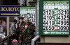 Two men look at a signs indicating the US dollar and euro rates near a currency exchange office in Moscow, Russia, Monday, Jan. 12, 2009. Russia's Central Bank allowed the ruble to drop sharply against the dollar Sunday, resuming a controlled devaluation of the currency that began Nov. 11 as the country's economy continued to weaken