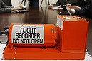 Reporters are seated at a table with a sample flight recorder at the National Transportation Safety Board (NTSB) Vehicle Recorder Laboratory in Washington, Friday, March 28, 2014. If searchers succeed in the Herculean task of retrieving the black boxes from Malaysia Airlines Flight 370 from the depths of the Indian Ocean, a new recovery job will begin _ to retrieve information from the flight data and voice recorders. (AP Photo/Charles Dharapak)