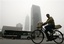 A cyclist and a bus pass by the high rise buildings shrouded in a haze of smog, in Beijing, Monday, Sept. 17, 2007. China launched its first nationwide urban public transport week on Sunday in an attempt to raise residents' awareness on energy saving and environmental protection. The "Green Transport and Health" campaign which covers 108 cities including Beijing, Shanghai and Tianjin, encourages people to walk, ride bicycles and take public transportation like buses, subways and taxies rather than drive private cars, to ease the pollution, the ministry