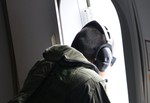 Naval Aircrewman (Operator) 1st Class Robert Pillars, assigned to Patrol Squadron (VP) 16, looks for floating debris while on a P-8A Poseidon during a mission to assist in search and rescue operations for Malaysia Airlines flight MH370, 24 March, 2014.