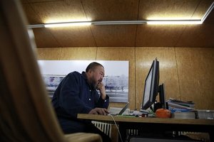 Chinese dissident artist Ai Weiwei works in front of a computer at home in Beijing, China, Tuesday, Nov. 8, 2011. Thousands of people have sent more than $800,000 to Ai, some tossing cash folded into airplanes over his gate, to help him pay a tax bill they see as government harassment, he said Monday. (AP Photo/Ng Han Guan)