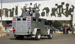 In this Saturday, Dec. 13, 2008, file photo, a private security company's armored vehicle rolls through Tahrir Square in central Baghdad, Iraq.