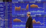 A pedestrian looks at an electronic market board of a securities company in Tokyo, Tuesday, March 24, 2009. The benchmark Nikkei 225 stock average soared 272.22 points, or 3.3 percent, to 8,488.30.