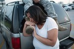 Lucy Hamlin and her husband, Spc. Timothy Hamlin, wait for permission to re-enter the Fort Hood military base, where they live, following a shooting on the base, Wednesday, April 2, 2014, in Fort Hood, Texas.