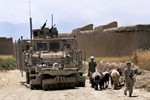 File - A U.S. Army member of a Counter Improvised Explosive Device Team  moves through an Afghan village to ensure roads are safe for travel in Pul-e Alam District, Logar province, Afghanistan, June  29, 2010.