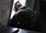 Naval Aircrewman (Operator) 1st Class David Everly, assigned to Patrol Squadron (VP) 16, looks for floating debris while on a P-8A Poseidon during a mission to assist in search and rescue operations for Malaysia Airlines flight MH370, 24 March, 2014.