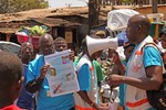 Health workers teach people about the Ebola virus and how to prevent infection, in Conakry, Guinea, Monday, March 31, 2014.