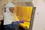 REPEATED FOR IMPROVED TONAL QUALITY- A medical worker from the U.S. Centers for Disease Control and Prevention, researchers who are working on the Ebola outbreak in Uganda, works at their laboratory in Entebbe 42kms (29 miles) from the capital Kampala Thursday Aug. 2, 2012.