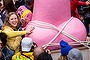 People pose for photos in front of a large pink phallic-shaped 'Mikoshi'  during Kanamara Matsuri (Festival of the Steel Phallus).