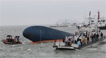 South Korean Coast Guard officers try to rescue missing passengers from a sunken ferry in the water off the southern coast near Jindo, South Korea, Thursday, April 17, 2014.