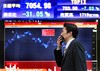 A man walks in front of the electronic stock board of a securities firm in Tokyo, Japan, Tuesday, March 10, 2009.