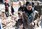 In this picture taken on Monday Feb. 24, 2014, and released by the United Nations Relief and Works Agency for Palestine Refugees in the Near East (UNRWA), residents of the besieged Palestinian camp of Yarmouk wait for a possible new UNRWA humanitarian aid distribution, in Damascus, Syria.