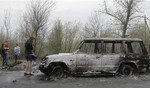 Local residents inspect burnt out cars after a night fight at the check point which was under the control of pro-Russian activists in the village of Bulbasika near Slovyansk, Ukraine, Sunday, April 20, 2014.