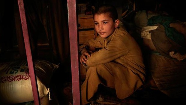 Sami Rahimi, 13, on his sleeping platform, where baking supplies are also kept.