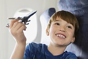 Boy playing with toy plane in airplane.