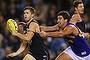 Marc Murphy of the Blues is tackled by Dean Cox of the Eagles during the round six AFL match between the Carlton Blues and the West Coast Eagles at Etihad Stadium on April 26, 2014