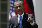 President Barack Obama answers a question during a joint news conference with German Chancellor Angela Merkel, Friday, May 2, 2014, in the Rose Garden at the White House in Washington. Obama and Merkel are putting on a display of trans-Atlantic unity against an assertive Russia, even as sanctions imposed by Western allies seem to be doing little to change Russian President Vladimir Putin's reasoning on Ukraine.