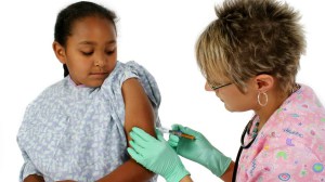 Girl receiving shot from a nurse