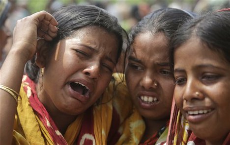 Relatives of victims killed in ethnic violence mourn at a burial ground at Narayanguri village, in the northeastern Indian state of Assam, Saturday, May 3 2014.