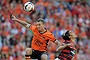 Besart Berisha of the Roar heads the ball towards the goal over Jerome Polenz of the Wanderers.