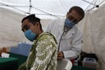 A doctor examines a man at a public health center set up to check for swine flu symptoms on residents in downtown Mexico City, Tuesday, April 28, 2009. World health officials raised a global alert to an unprecedented level as the swine flu was blamed for more deaths in Mexico and the epidemic crossed new borders, with the first cases confirmed Tuesday in the Middle East and the Asia-Pacific region.(AP Photo/Rodrigo Abd)