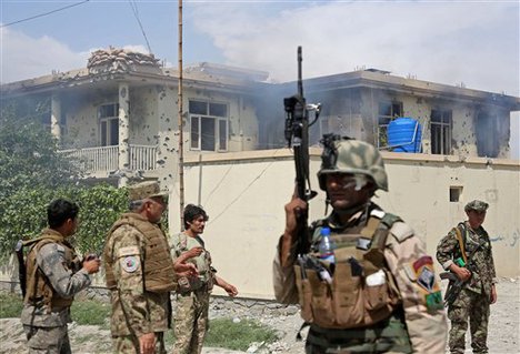 Afghan police officers arrive to the scene after Taliban fighters stormed a government building in Jalalabad, east of Kabul, Afghanistan, Monday, May 12, 2014.