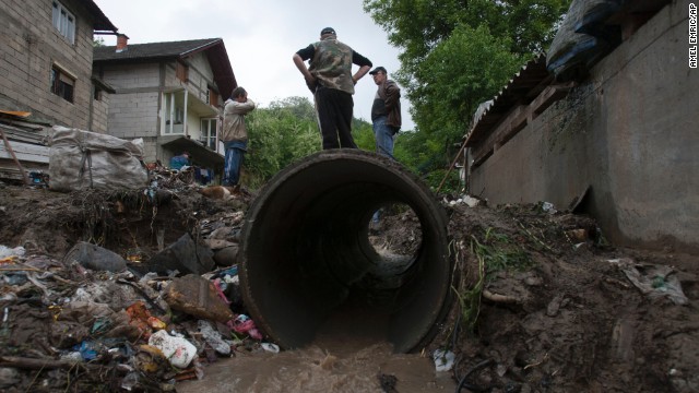 People work to clear debris from a small stream that was clogged and causing localized flooding near their homes in Tuzla, Bosnia-Herzegovina, on Sunday, May 12.