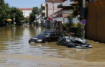 A severely damaged car stands in a flooded street in Obrenovac, some 30 kilometers (18 miles) southwest of Belgrade, Serbia, Monday, May 19, 2014.