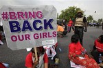 A police officer stands guard as people attend a demonstration calling on the government to rescue the kidnapped girls of the government secondary school in Chibok, in Abuja, Nigeria, Thursday, May 22, 2014.