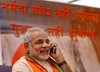 Chief Minister of Gujarat state Narendra Modi talks on his mobile phone, on the second day of Modis hunger strike against stopping of the of the work at the Narmada Dam, in Ahmadabad, India, Monday, April 17, 2006. India's Supreme Court ordered Monday that work on the controversial dam should continue, but that the federal government must ensure that tens of thousands of villagers who will be displaced by the massive power project are adequately compensated and resettled, a news agency said. In the background is written Narmada Dam will not stop, Gujarat will not bow down.