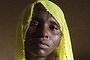 Rachel Daniel, 35, holds up a picture of her abducted daughter Rose Daniel, 17, as her son Bukar, 7, sits beside her at her home in Maiduguri, Nigeria.