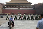 Chinese paramilitary policemen march in front of the entrance to the Forbidden City near Tiananmen Square in Beijing Wednesday, June 4, 2014.