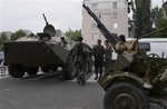 Pro-Russian militia members guard next to an APC and anti-aircraft gun, outside the administrational building in Donetsk, Ukraine, on Thursday, May 29, 2014.