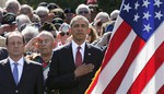 U.S. President Barack Obama, center, and French President Francois Hollande, left, participate in the 70th French-American commemoration D-Day ceremony at the Normandy American Cemetery and Memorial in Colleville-sur-Mer, France on Friday, June 6, 2014