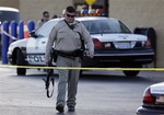 A Las Vegas police officer walks away from the scene of a shooting near a Wal-Mart, Sunday, June 8, 2014, in Las Vegas.