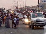 In this still image posted on a militant Twitter account on Wednesday, June 11, 2014, which has been authenticated based on its contents and other AP reporting, militants parade down a main road in Mosul, Iraq.