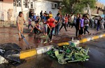 People clean up in the aftermath of a suicide bomb attack in Baghdad's Sadr City, Iraq, Wednesday, June. 11, 2014.