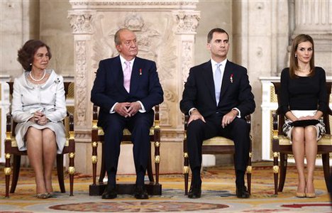 Spain's Queen Sofia, left sits with King Juan Carlos, 2nd left, Spanish Crown Prince Felipe, 3rd left and Princess Letizia before signing an abdication law during a ceremony at the Royal Palace in Madrid