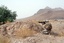 U.S. Navy Hospitalman Apprentice Brian Rumbles fires on two Taliban fighters fleeing up the side of a mountain while on a mounted patrol outside of Bala Baluk's forward operating base in the Farah Province.