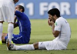 Uruguay's Luis Suarez holds his teeth after running into Italy's Giorgio Chiellini's shoulder during the group D World Cup soccer match between Italy and Uruguay at the Arena das Dunas in Natal, Brazil, Tuesday, June 24, 2014.