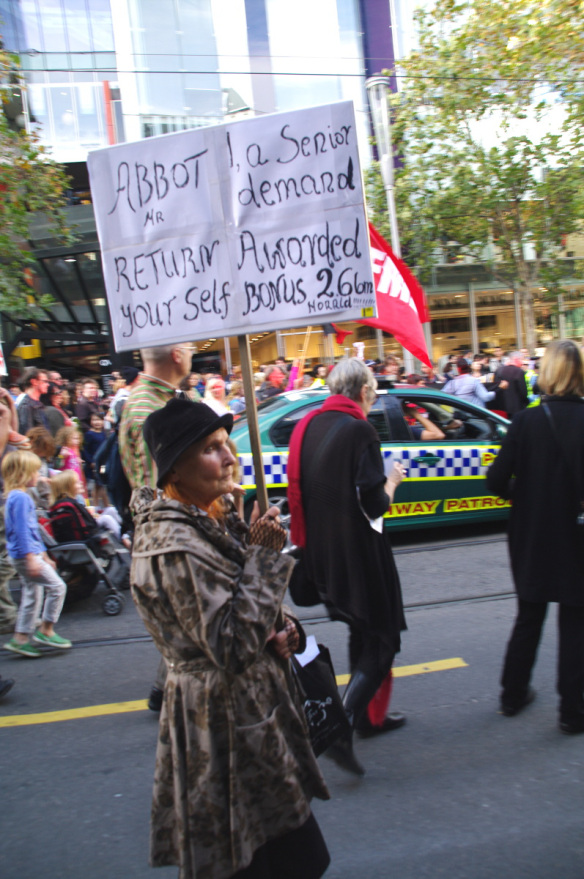 Senior citizen with placard demanding Abbott reurn his 'self-awarded bonus'