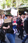 woman holding baby with mini-placard reading "Wah!!!"