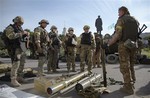 Ukrainian government army soldiers examine weapons captured from rebels in the city of Slovyansk, Donetsk Region, eastern Ukraine Saturday, July 5, 2014.