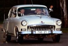 Russian President Vladimir Putin sits in the passenger seat as US President George W. Bush waves while driving Putin's 1956 Volga in Novo Ogarevo.  REUTERS/Kevin Lamarque