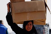 A Syrian refugee carries boxes of aid at Al-Zaatri refugee camp in the Jordanian city of Mafraq, near the border with Syria December 31, 2013. REUTERS/Muhammad Hamed (JORDAN - Tags: POLITICS CIVIL UNREST CONFLICT SOCIETY)