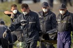 Emergency workers carry the body of a victim at the crash site of Malaysia Airlines Flight 17 near the village of Hrabove, eastern Ukraine, Saturday, July 19, 2014.