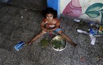 A Palestinian girl sits on the floor at the Abu Hussein U.N. school, hit by an Israeli strike earlier, in the Jebaliya refugee camp, northern Gaza Strip, Wednesday, July 30, 2014.